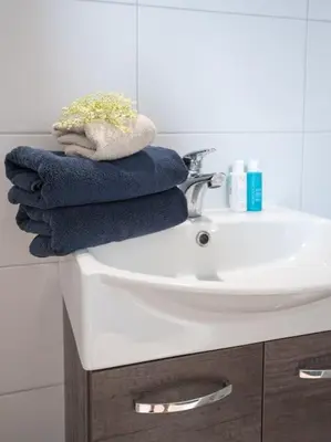 a pile of towels sitting on top of a bathroom sink at Hosted by wendy Old city charming accommodation in Wassenaar