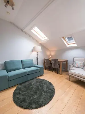 a living room with a blue couch and a table at Hosted by wendy Old city charming accommodation in Wassenaar