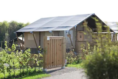 a small building with a blue roof in a garden at Safari Lodges Premium in Nieuwe Wetering