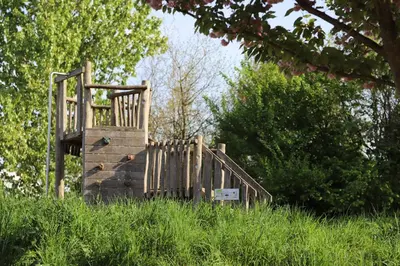 a wooden playground in a field of tall grass at Safari Lodges Premium in Nieuwe Wetering