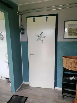 a room with a door with a starfish on the wall at Tinyhouse CARPE DIEM in Dirkshorn