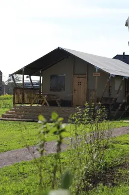a small building with a tent in a field at Safari Lodges XL in Nieuwe Wetering