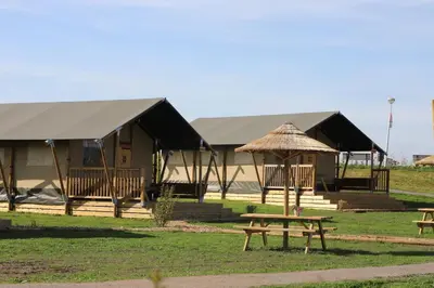 a building with a picnic table and a tent at Safari Lodges XL in Nieuwe Wetering