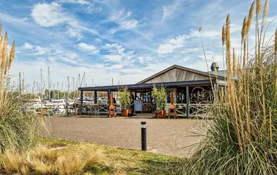 a building sitting next to a marina with chairs and tables at Johannesburg in Naarden