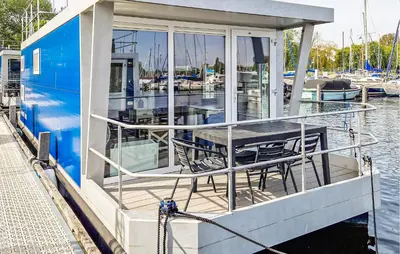 a dock with a table and chairs on a boat at Trancoso in Naarden