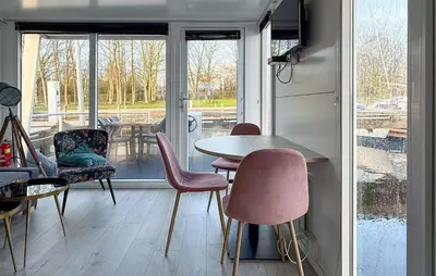 a dining room with a table and chairs and a window at Trancoso in Naarden