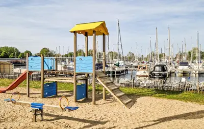 a playground with a slide in the sand near a marina at Trancoso in Naarden
