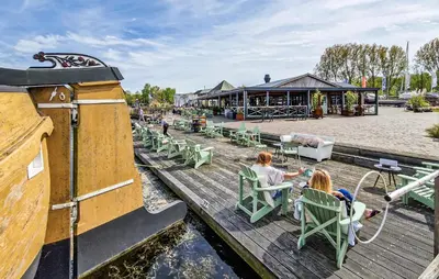 two girls sitting in chairs on a wooden dock at Lissabon in Naarden