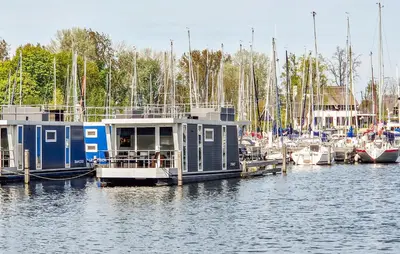 a house boat docked at a marina with boats at Lissabon in Naarden