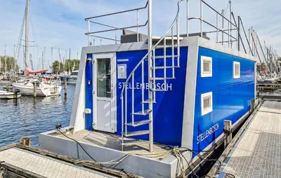 a blue boat docked at a dock in the water at 2 Bedroom Amazing Ship In Naarden in Naarden