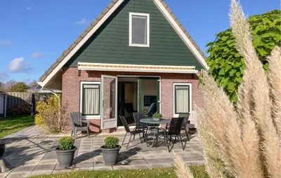 a house with a patio with chairs and a table at Pet Friendly Home In Opperdoes in Opperdoes