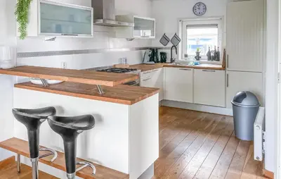 a kitchen with white cabinets and black stools at Pet Friendly Home In Opperdoes in Opperdoes