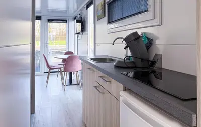 a kitchen with a sink and a table with chairs at Amsterdam in Naarden