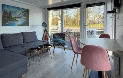 a living room with a couch and a table and chairs at Stellenbosch in Naarden