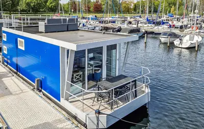 a blue boat docked at a marina with boats at Brussel in Naarden