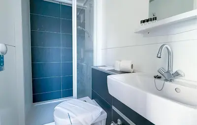 a bathroom with a sink and a toilet and blue tiles at New York in Naarden