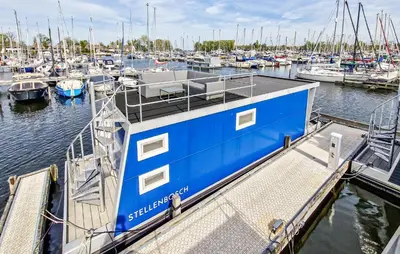 a blue boat is docked at a marina at Monaco in Naarden