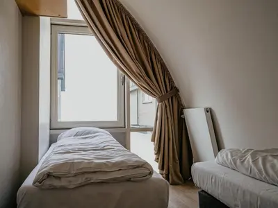 a bedroom with a bed and a window with curtains at Seaside Stay in Egmond in Egmond aan Zee