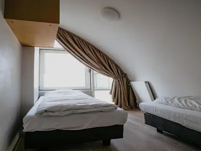 a bedroom with two beds and a window at Seaside Stay in Egmond in Egmond aan Zee