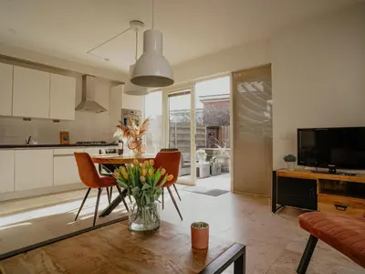 a kitchen and living room with a table and chairs at Seaside Stay in Egmond in Egmond aan Zee