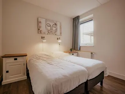 a bedroom with a large white bed and a window at Spacious Lakeside Retreat in Uitgeest