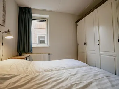 a bedroom with a white bed and a window at Spacious Lakeside Retreat in Uitgeest