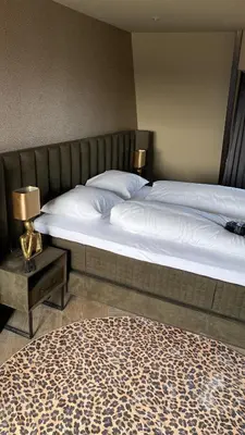 a bedroom with two beds and a table with a bed sidx sidx sidx at Boutique Hotel Noordeinde in Rijnsburg