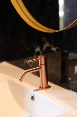 a bathroom sink with a copper faucet at Boutique Hotel Noordeinde in Rijnsburg