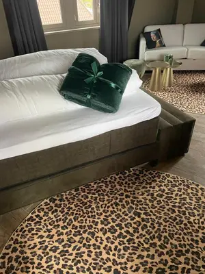 a bed with a green bow on top of it at Boutique Hotel Noordeinde in Rijnsburg