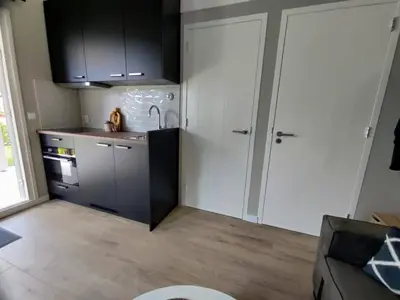 a kitchen with white cabinets and a sink and a counter at Park De Driesprong in Nieuwveen