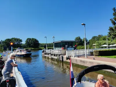 two people on a boat on a river with boats at Park De Driesprong in Nieuwveen