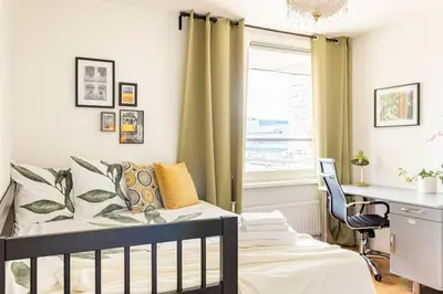 a bedroom with a crib and a desk and a window at My Apartment on the Water in Amsterdam