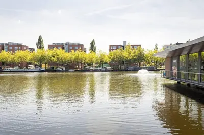 a river with a building next to a city at My Apartment on the Water in Amsterdam