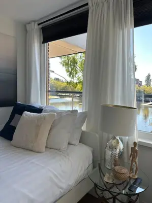 a bedroom with a bed with a large window at My Apartment on the Water in Amsterdam