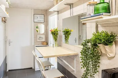 a small kitchen with a table and chairs and plants at My Apartment on the Water in Amsterdam