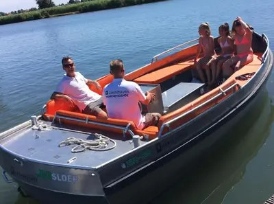 a group of people sitting in a boat on the water at Design huisje vrij in het groen in IJsselstein