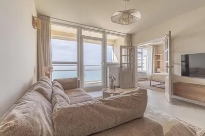 a living room with a large couch and a television at Casa Buena Vista in Egmond aan Zee