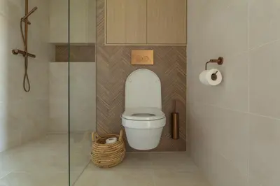 a bathroom with a toilet with a glass shower stall at Casa Buena Vista in Egmond aan Zee