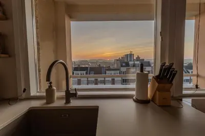 a kitchen counter with a window overlooking a city at Casa Buena Vista in Egmond aan Zee