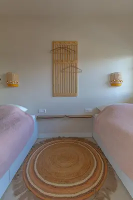 a room with two beds and a rug on the floor at Casa Buena Vista in Egmond aan Zee