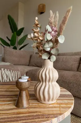 a white vase with flowers on a coffee table at Casa Buena Vista in Egmond aan Zee