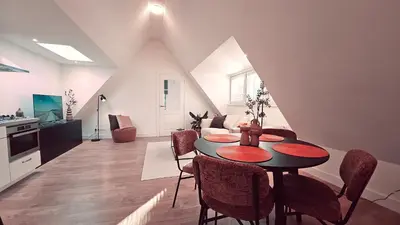 a living room with a dining room table and a kitchen at Tante Bed 44A in Voorschoten