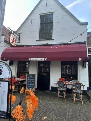 a restaurant with a table and chairs in front of a building at Tante Bed 44A in Voorschoten