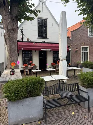 a group of tables and benches in front of a building at Tante Bed 44A in Voorschoten