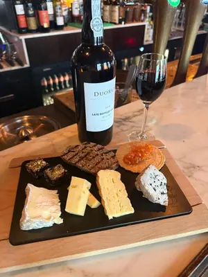 a plate with a bottle of wine and a wine glass at Tante Bed 44A in Voorschoten
