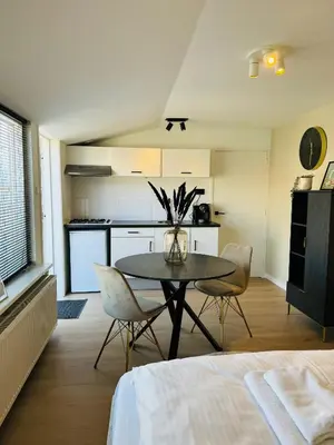 a kitchen and dining room with a table and chairs at Studio 41 Sunshine in Noordwijk aan Zee