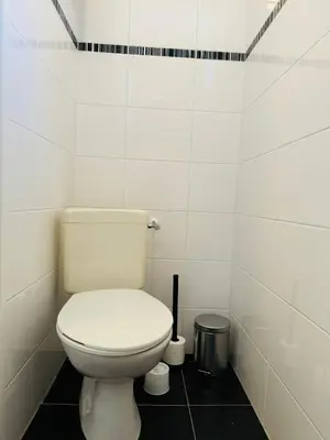 a bathroom with a white toilet and a trash can at Studio 41 Sunshine in Noordwijk aan Zee