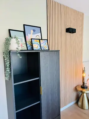a black book shelf with pictures on top of it at Studio 41 Sunshine in Noordwijk aan Zee