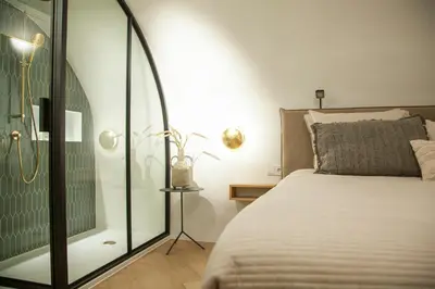a bedroom with a bed and a glass shower at The Stork - In luxe logeren aan de Oudegracht, Centrum Utrecht in Utrecht