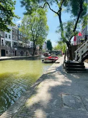 a boat is docked on a river in a city at The Stork - In luxe logeren aan de Oudegracht, Centrum Utrecht in Utrecht